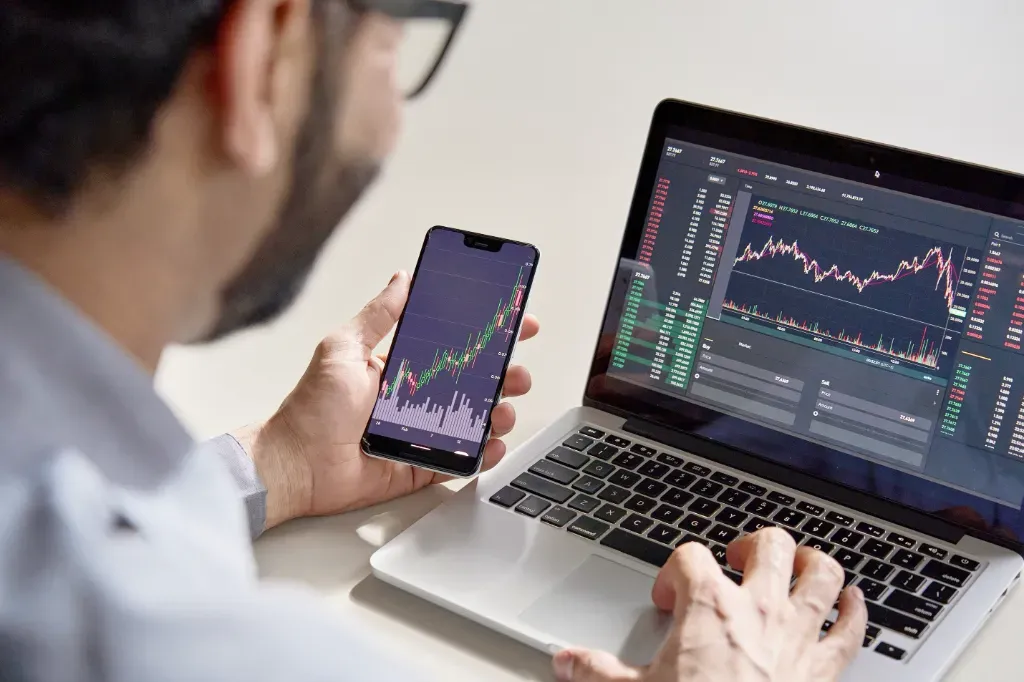 Mężczyzna inwestujący na TradingView w aplikacji mobilnej i na stronie internetowej